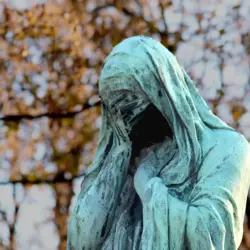 Día Internacional Viudas Día Internacional de las Viudas por qué se conmemora este 23 de junio y cuál es su importancia | Bronze statue of a hooded figure covering its face green patina with autumn foliage in the background