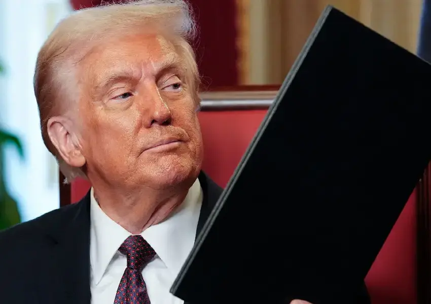 Trump impone aranceles a Canada Trump impone aranceles de 50 a productos de Canadá y escala la tensión comercial en Norteamérica | Man in a dark suit and tie sits holding a large black folder or binder looking to the side in a formal setting