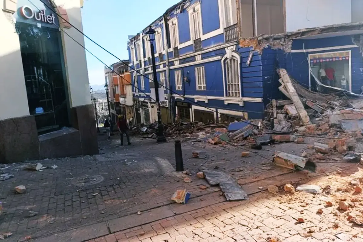 terremotocolombia Terremoto de 74 en Colombia causa daños heridos y dos muertos en Manizales | Street scene after a building collapse with a blue multi story row house and rubble filling the cobblestone street