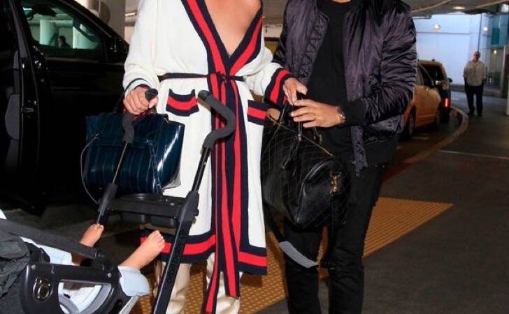 Esposa de John Legend casi quedó desnuda. Con bolso y bebé en mano no pudo sujetar su ropa que caía