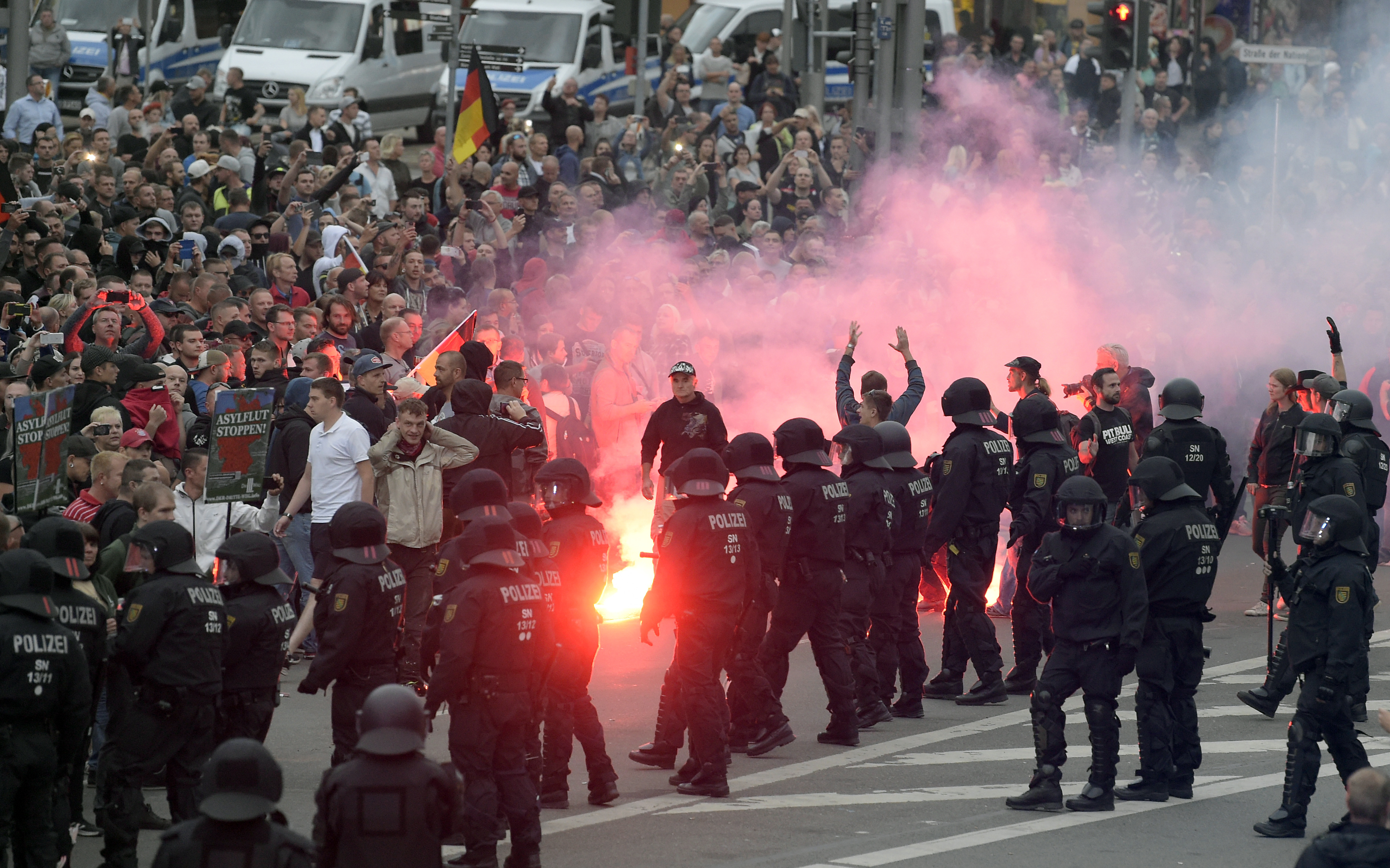 Los manifestantes encienden fuegos artificiales durante una manifestación de extrema derecha en Chemnitz, Alemania (AP Photo/Jens Meyer)