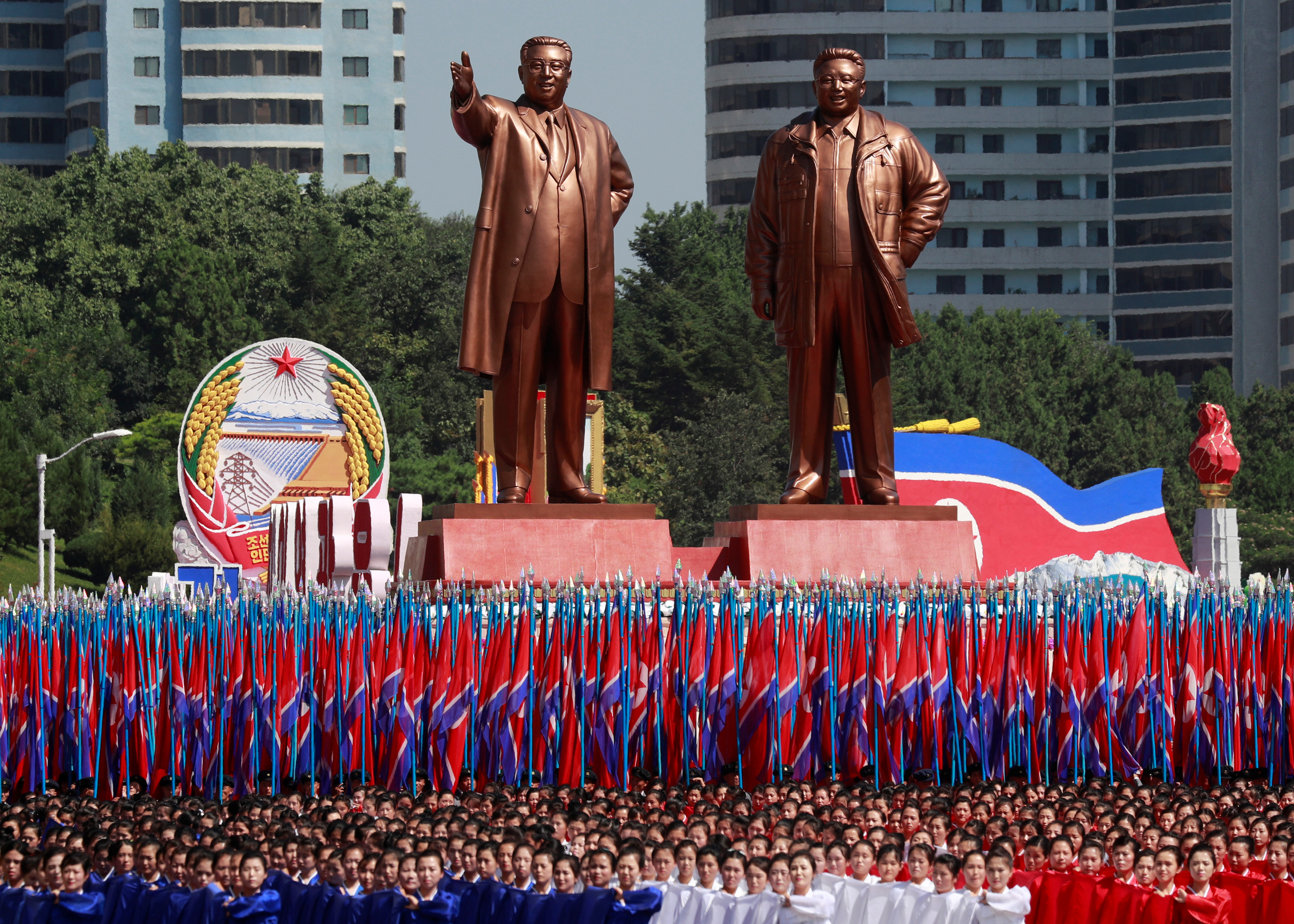 Miles de personas cargan banderas de Corea del Norte ante las estatuas de Kim Il Sung y Kim Jong Il . (REUTERS/Danish Siddiqui)