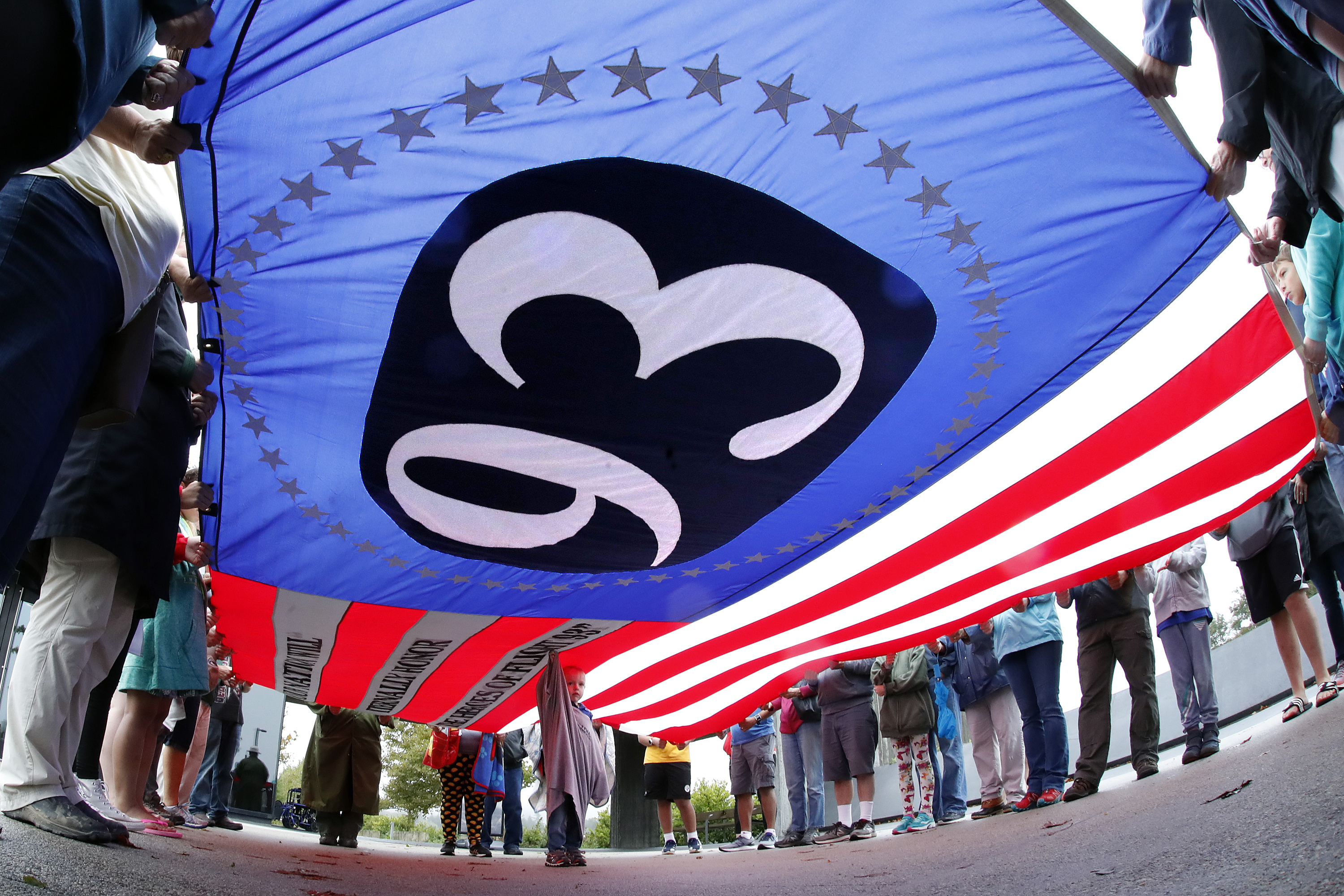 Visitantes del sitio con una bandera del vuelo 93 (AP/Gene J. Puskar)