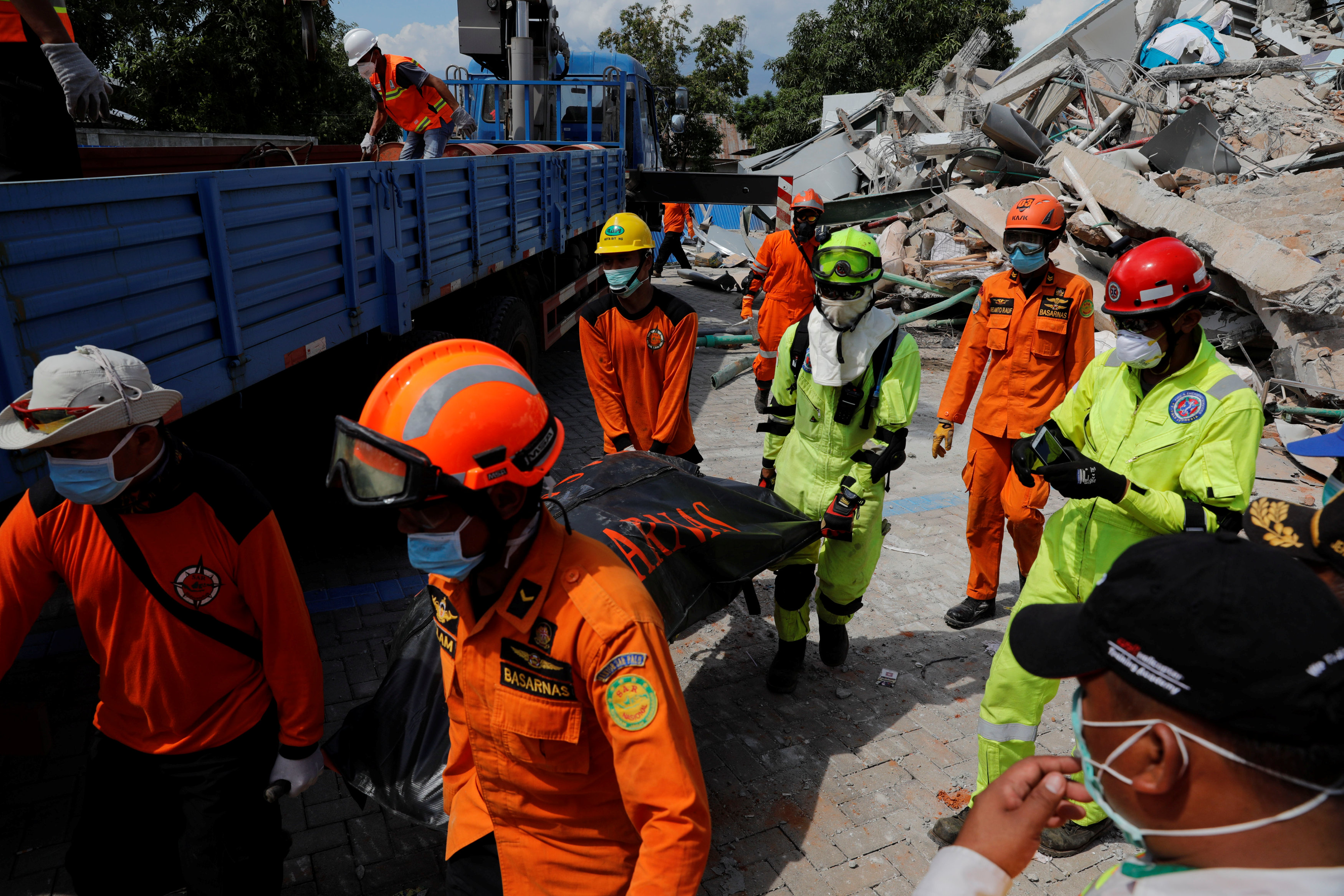 Socorristas cargan el cuerpo de una persona fallecida en el derrumbe del hotel Roa-Roa en Palu (REUTERS/Beawiharta)