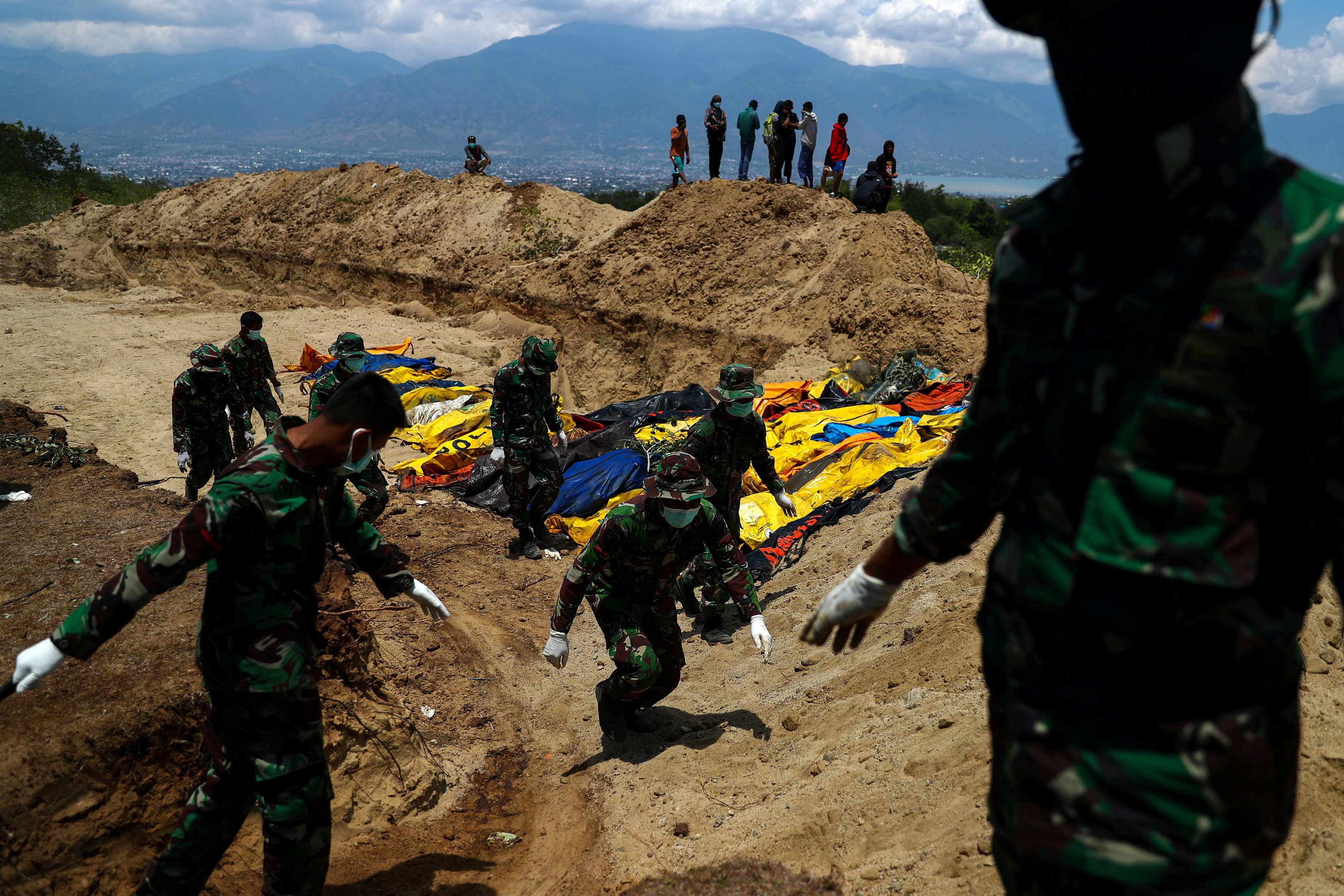 Soldados sepultan los cuerpos de víctimas del terremoto en una fosa común en el cementerio de Poboya en Palu (REUTERS/Athit Perawongmetha)