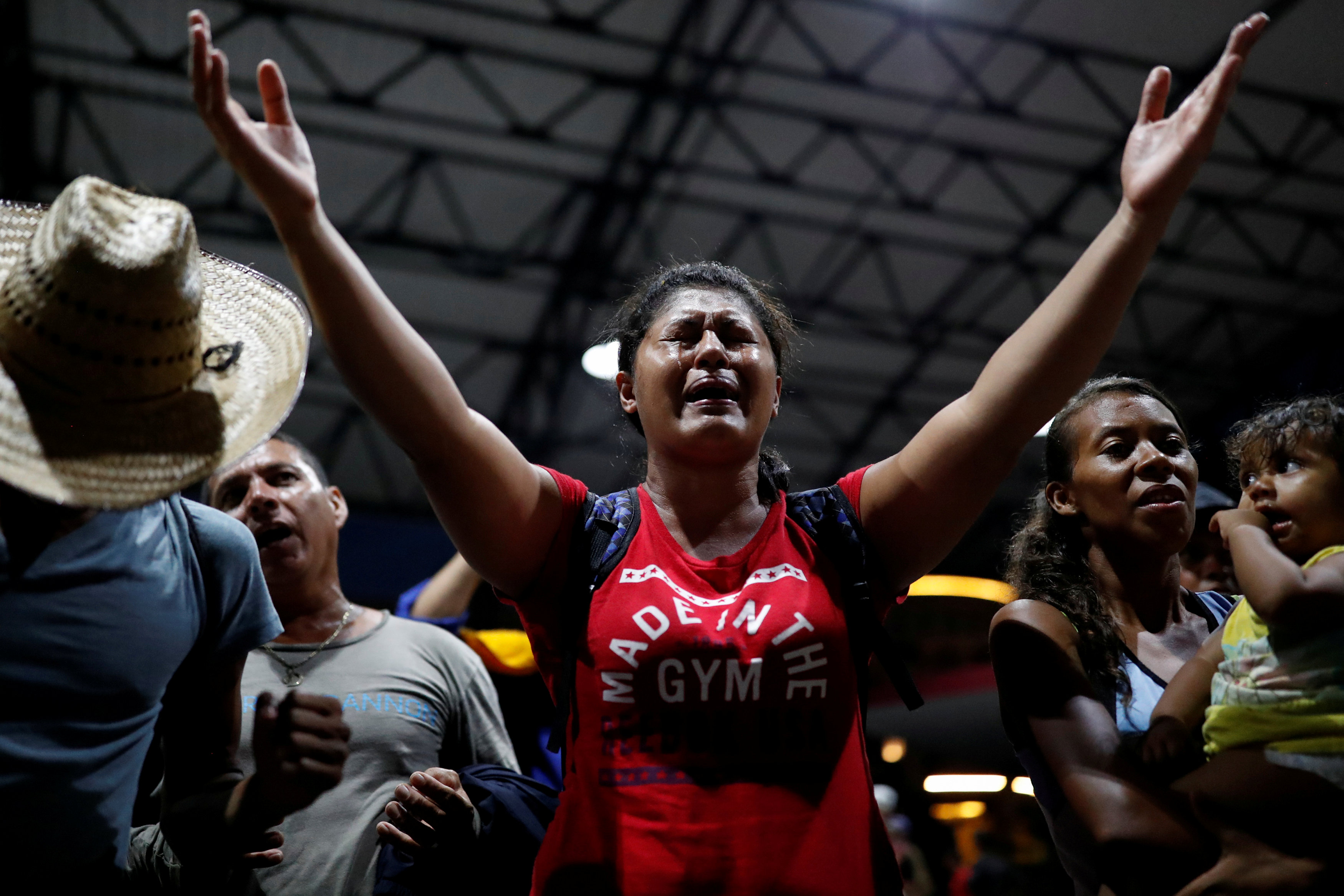 Una mujer centroamericana de la segunda caravana migrante cata y reza en la plaza pública de  Tapachula, Mexico (REUTERS/Carlos Garcia Rawlins)