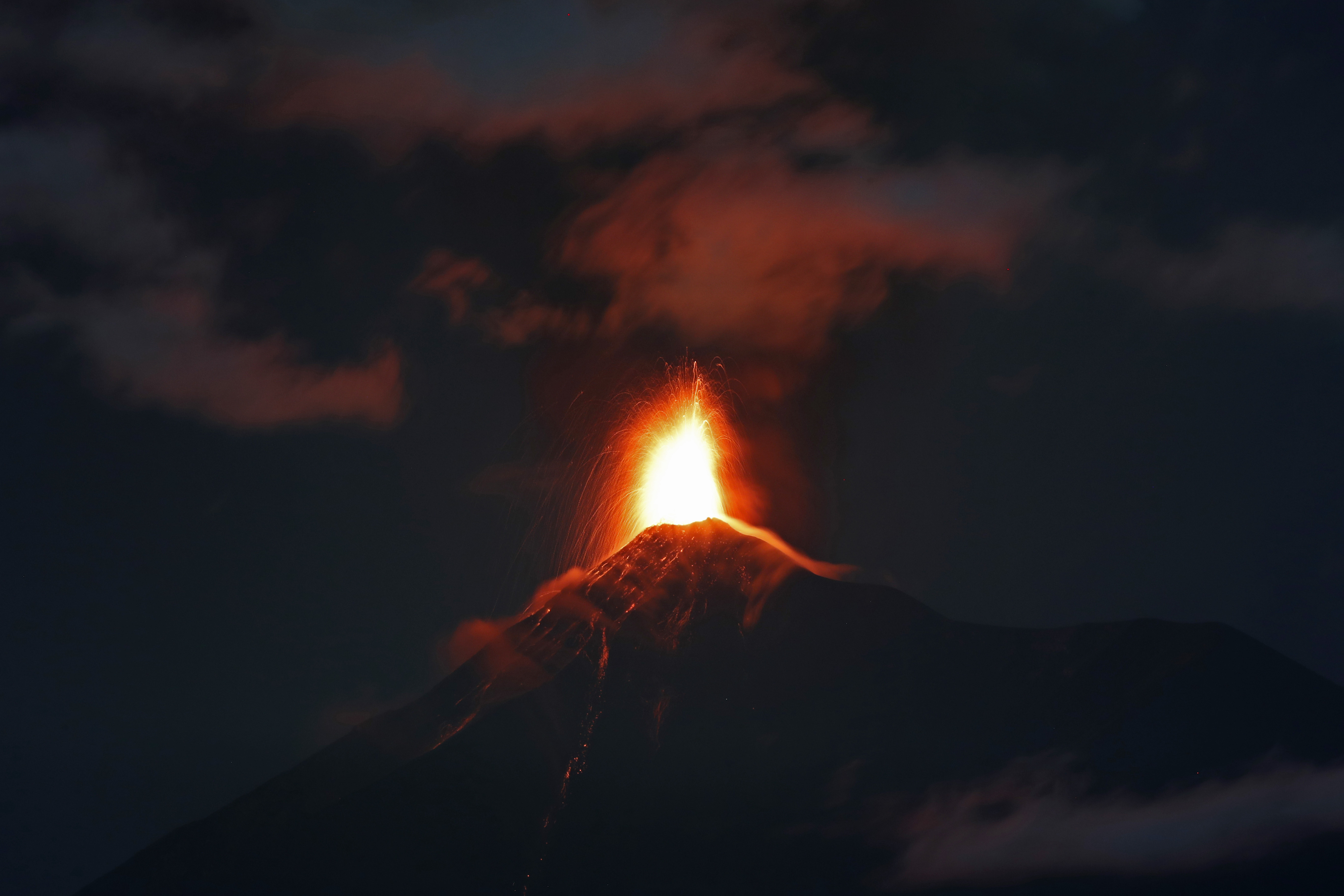 Imagen del Volcán de Fuego en Antigua, Guatemala, la madrugada del lunes 19 de noviembre de 2018. Las autoridades evacuaron comunidades aledañas tras un incremento en la actividad del coloso. (AP Foto/Moises Castillo)