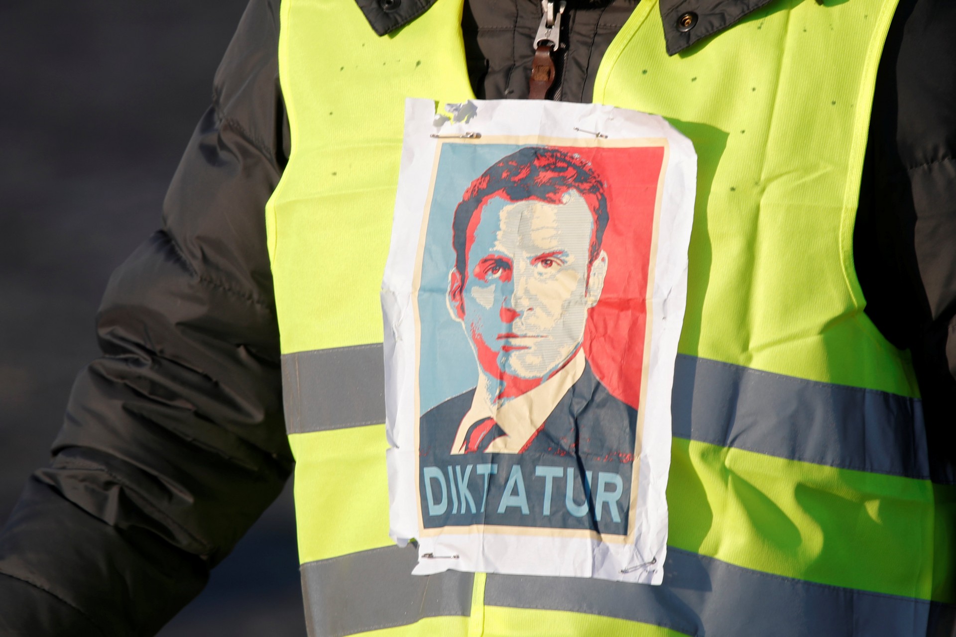 Un manifestante de chalecos amarillos con la cara del presidente Macron y la palabra “dictador” (REUTERS/Charles Platiau)