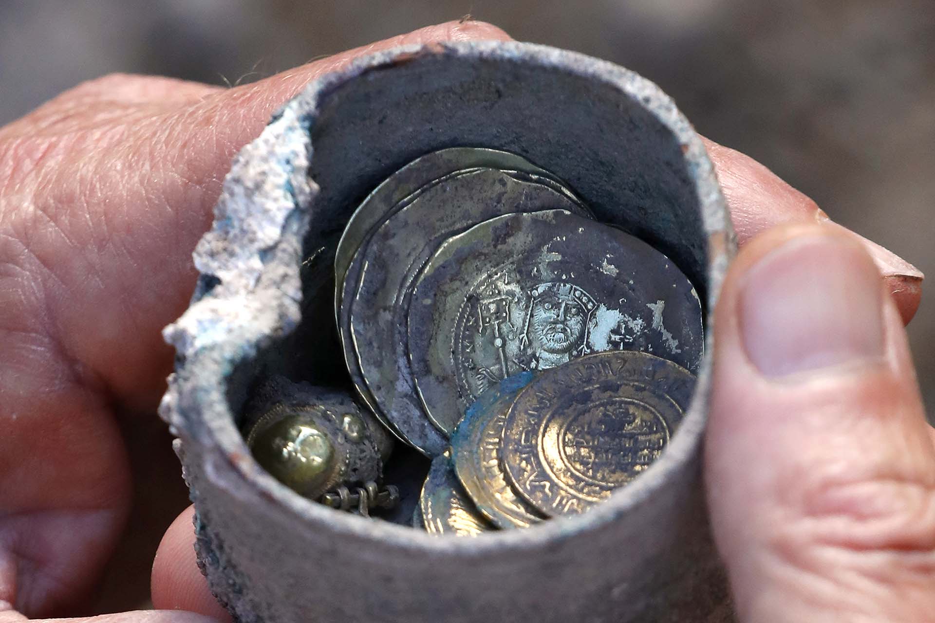 El tesoro, un pequeño cofre de bronce que contiene 24 monedas de oro y un pendiente del mismo metal precioso, fue desenterrado hace pocos días en el Parque Nacional de Cesárea, extraído de entre dos piedras al lado de un pozo situado en una casa de un vecindario de hace casi un milenio, informó un comunicado