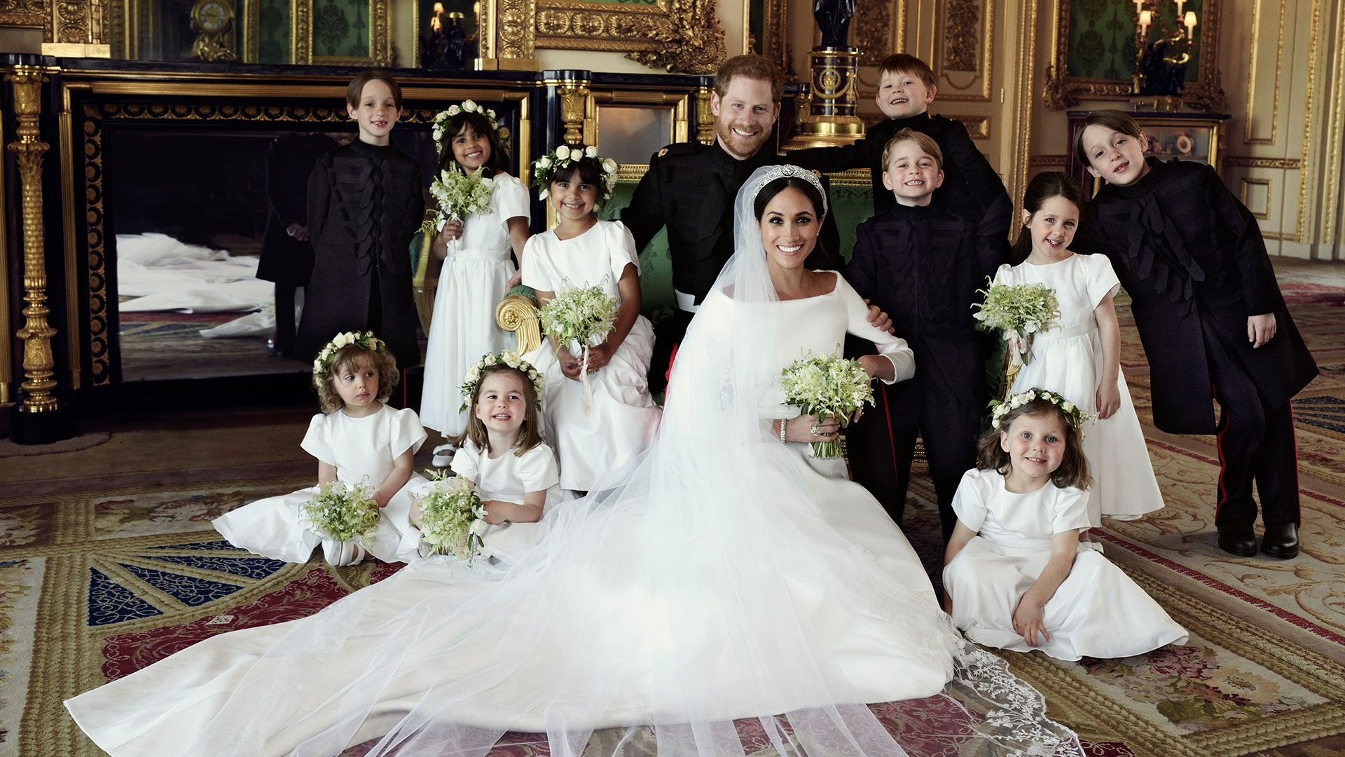 El príncipe Harry y Meghan Markle el día de su boda, el 19 de mayo pasado. Junto a ellos, Charlotte, la hija de William y Kate Middleton que fue protagonista de una dura pelea entre ambas duquesas (AFP)