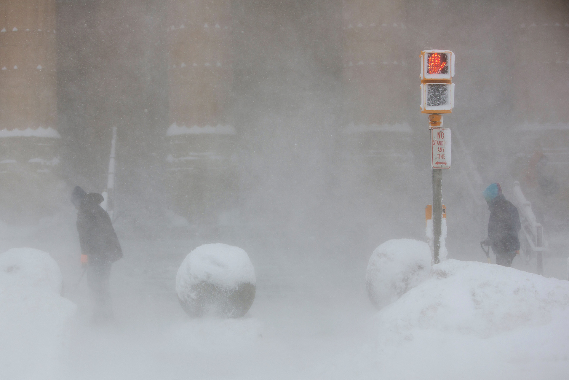 Trabajadores tratan de despejar la entrada al Ayuntamiento de Buffalo, en medio de una tormenta de nieve.