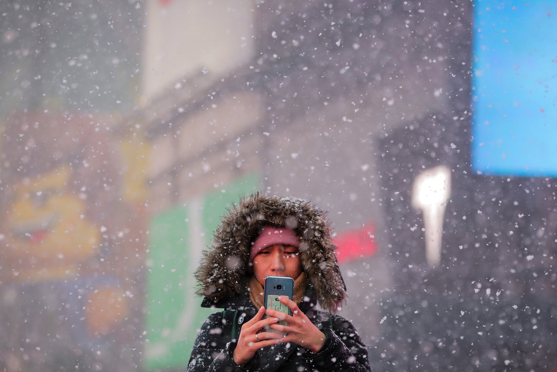 Otra mujer toma fotos en Times Square, en medio del frío y la nieve.