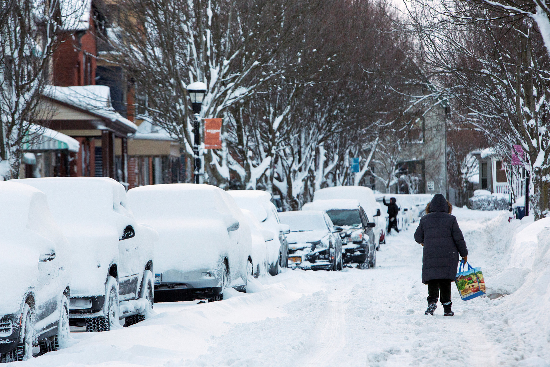 Una mujer camina por una calle de Buffalo, donde ha acumulado la nieve.