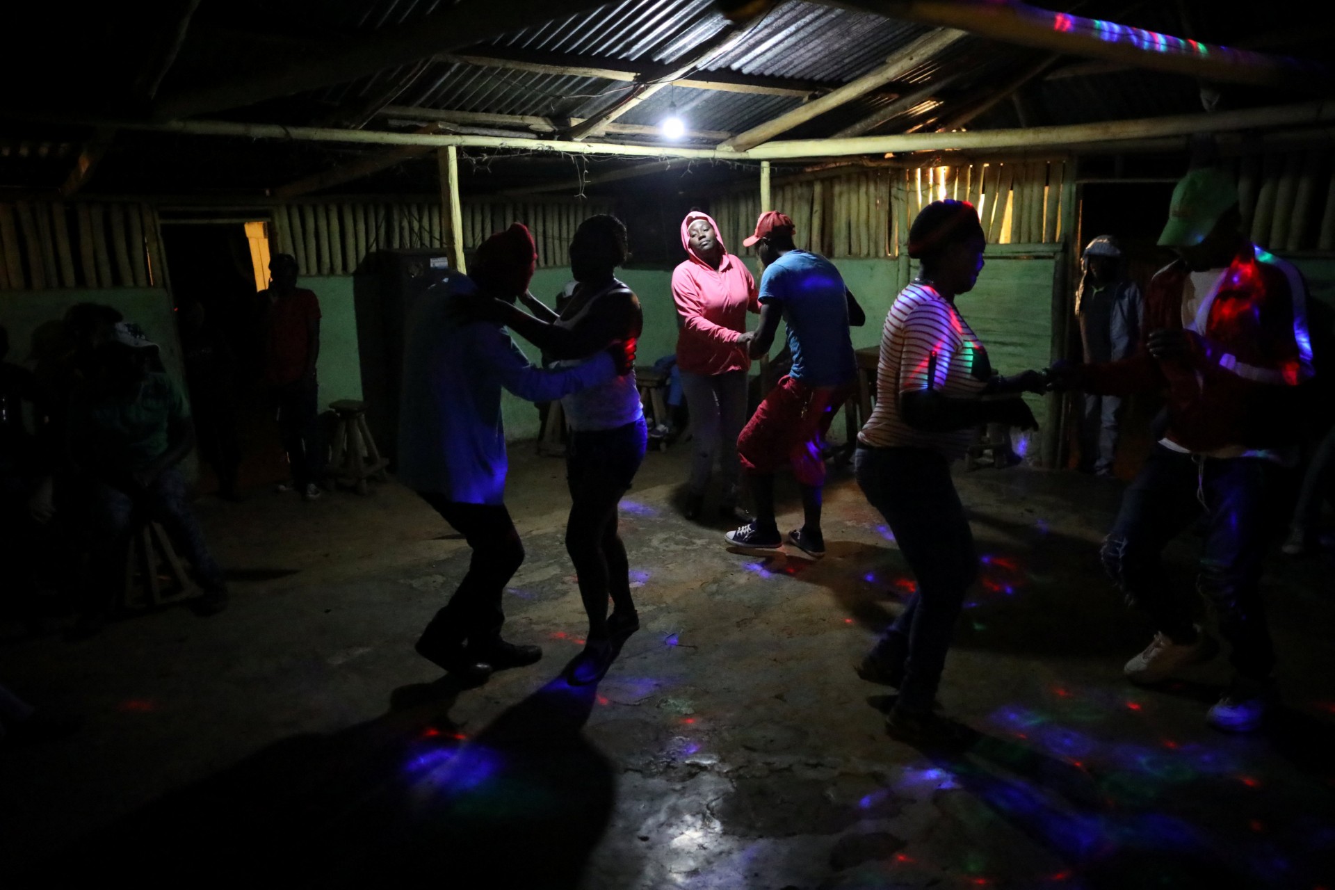 Los residentes bailan en un bar en Boucan Ferdinand, Haití, el 8 de abril de 2018. La noche del domingo es el único momento en que el bar está abierto y los residentes se reúnen allí para socializar y bailar.