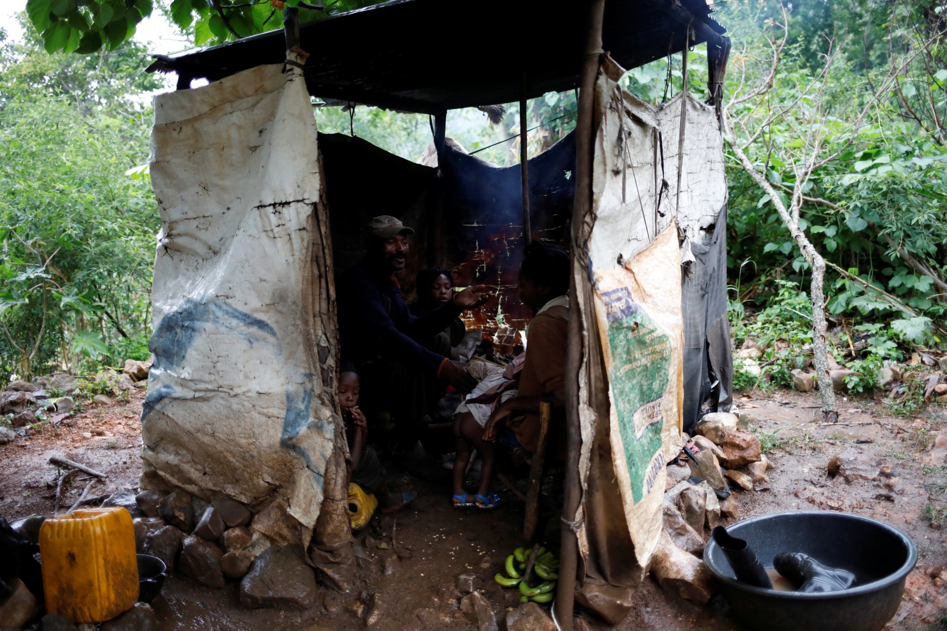 Una familia cena en una cocina improvisada frente a una casa en Boucan Ferdinand, Haití, 7 de octubre de 2018.