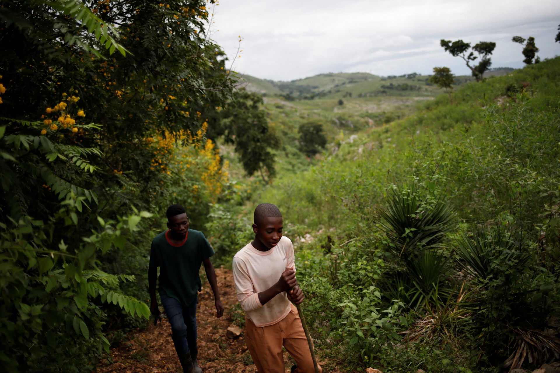 Los muchachos caminan a lo largo de un sendero que conecta con Bois Negresse, utilizado en el pasado por vehículos todo terreno  en las afueras de Boucan Ferdinand, Haití, 10 de octubre de 2018.