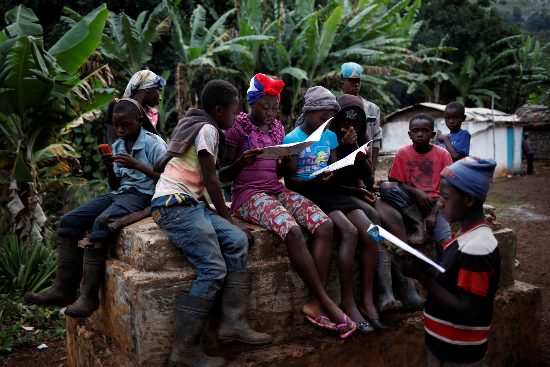 Los niños se reúnen y leen libros escolares en Boucan Ferdinand, Haití, 4 de octubre de 2018.