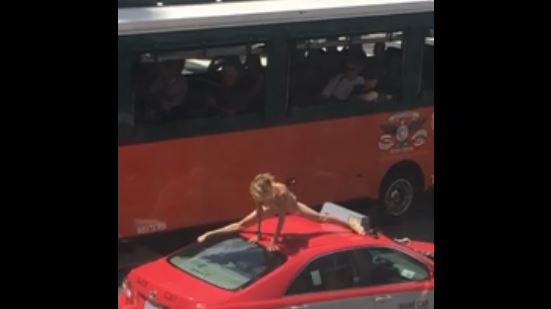 Mujer hace yoga desnuda en el techo de un taxi | VIDEO