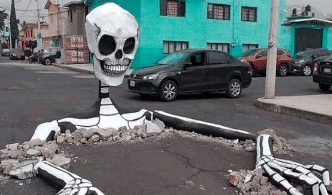 Vecinos utilizan baches en pistas para poner calaveras gigantes