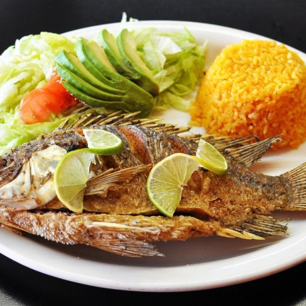 Mojarra frita al mojo de ajo con ensalada, receta mexicana