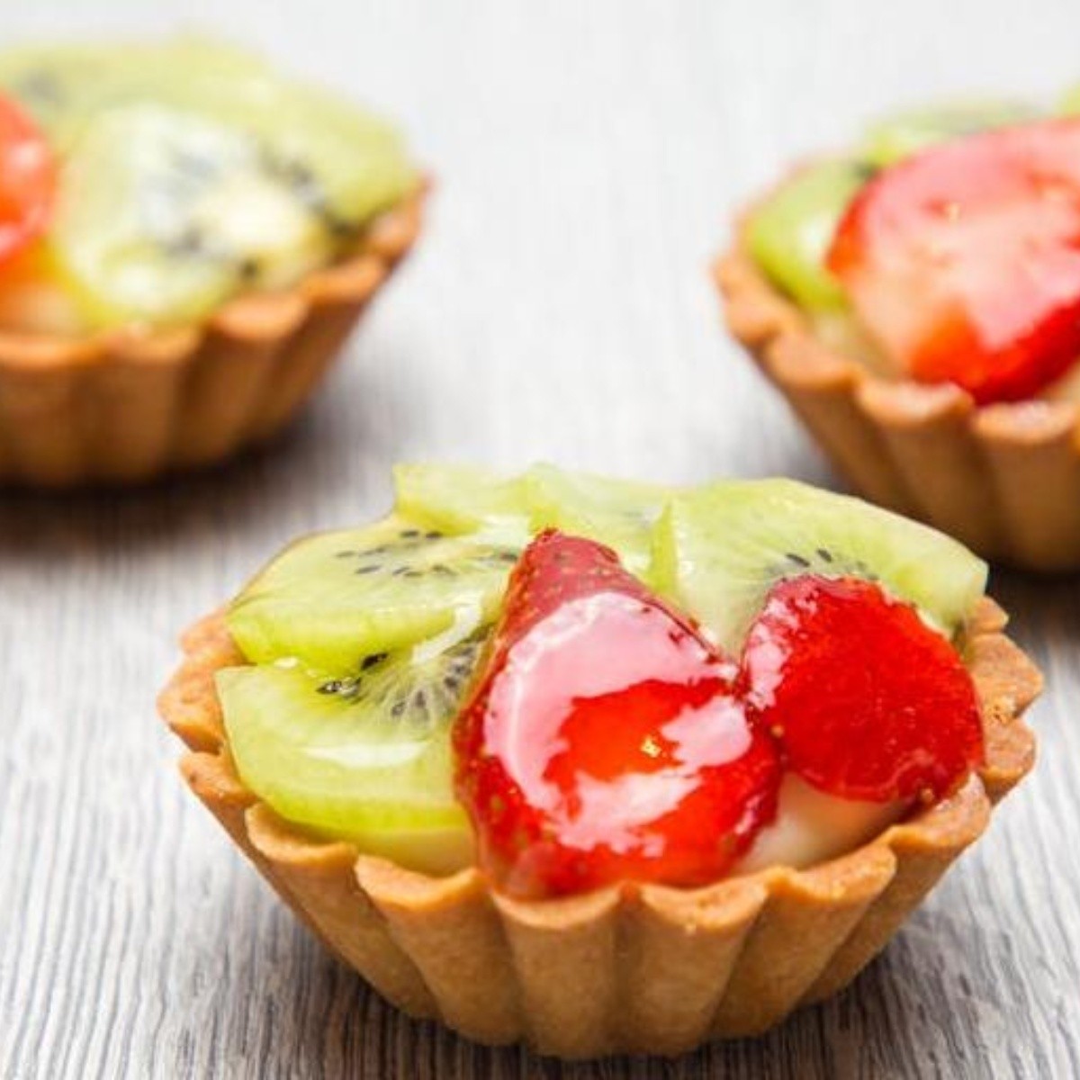 Tartaletas con harina de almendra, crema batida y frutas