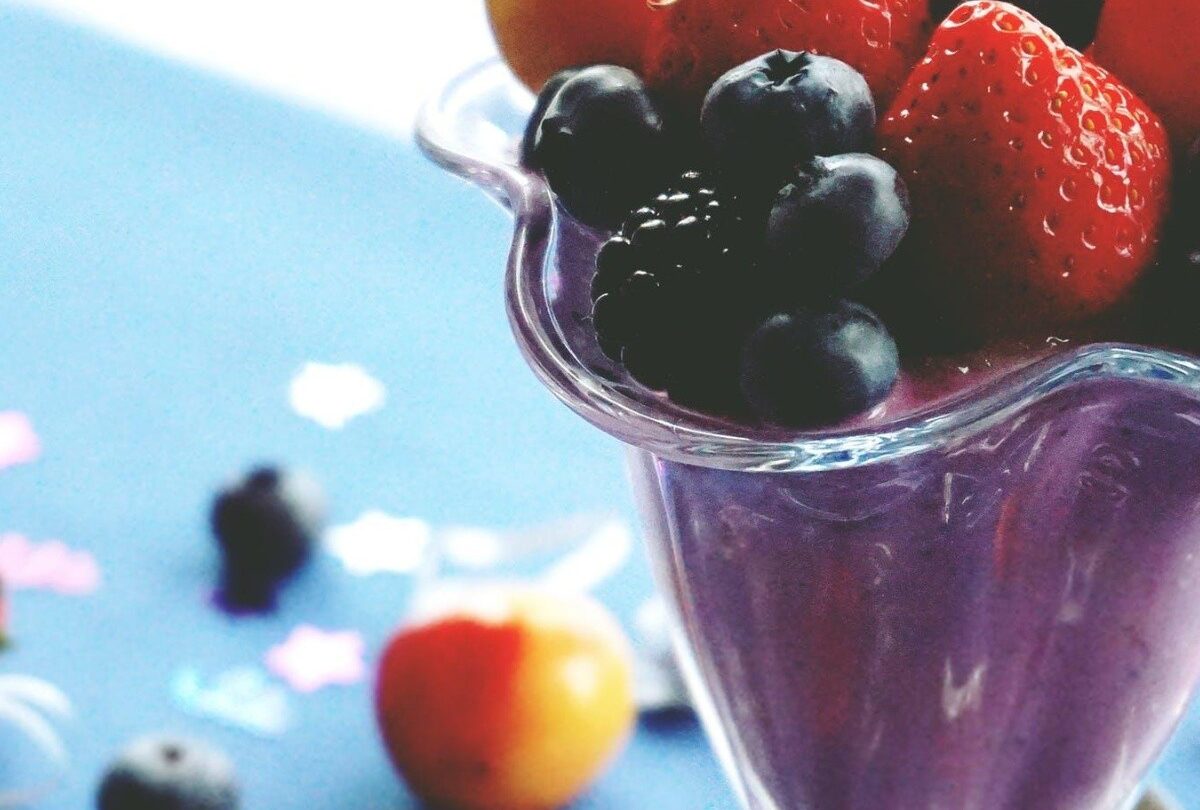 Smoothie púrpura con fresas arándanos frescos y frambuesas |
