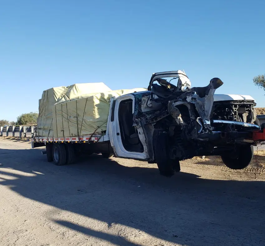 Camioneta plataforma destrozada tras chocar contra tráiler