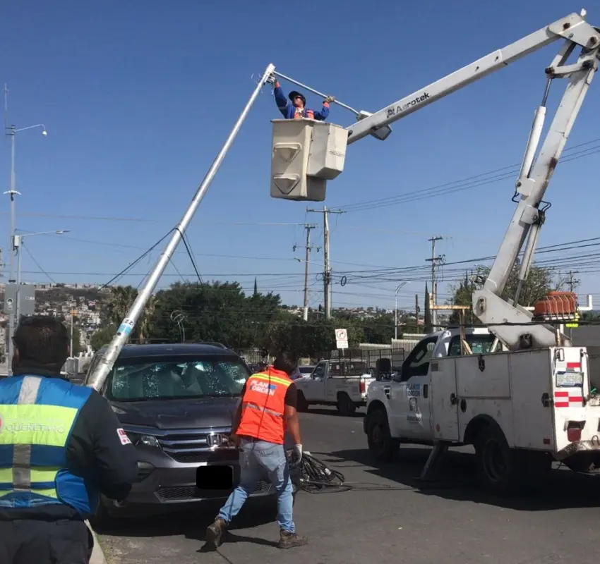 Luminaria derribada por camión cae sobre camioneta estacionada