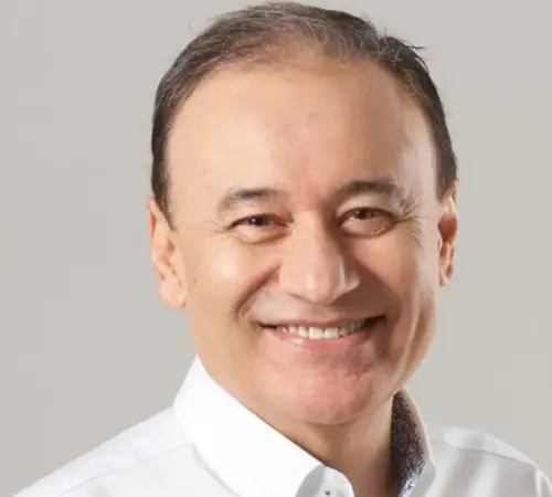 Smiling middle aged man in a white shirt against a gray backdrop