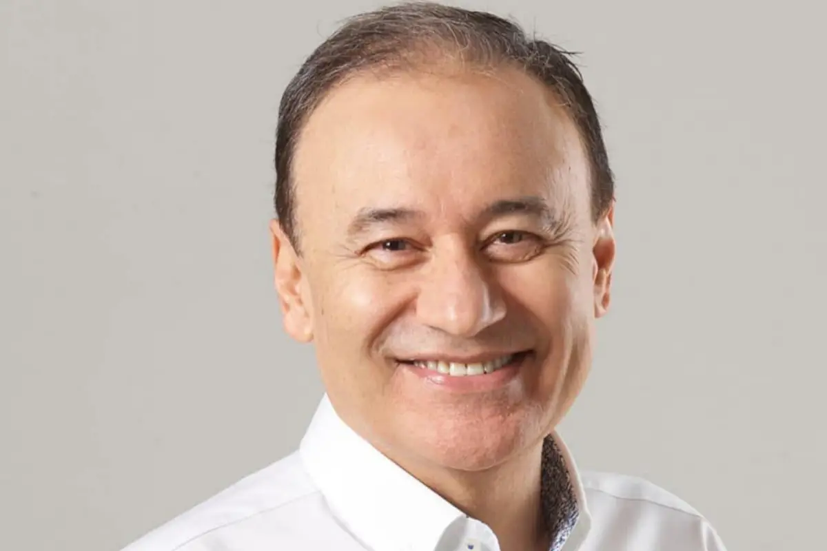 Smiling middle aged man in a white shirt against a gray backdrop
