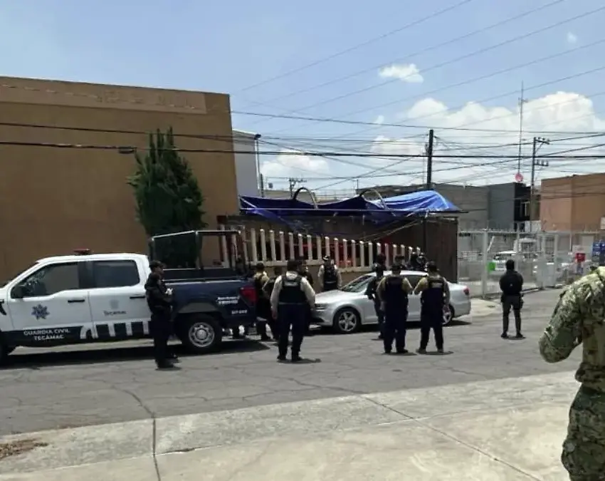 Operativo en Tecámac continúa versiones sobre presuntos rehenes generan confusión | Marina military personnel guard a street near a gated area with a white police pickup and a blue tarped barrier in the background
