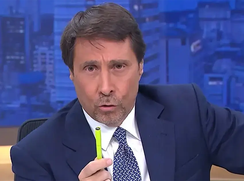 Periodista argentino ofrece disculpas tras polémica por comentarios contra los mexicanos | News anchor in a navy suit speaks while holding a bright yellow green pen toward the cameradesk